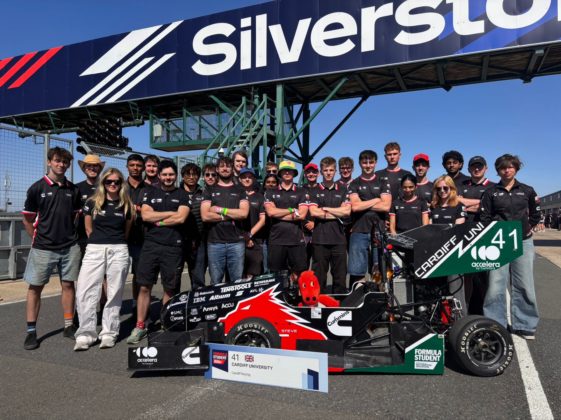 Cardiff Racing team members standing with their Formula Student car at Silverstone